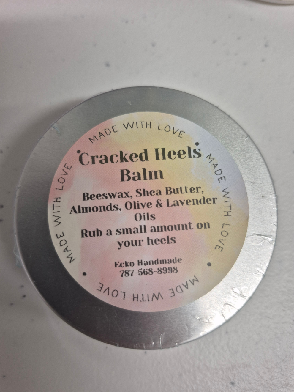 Round metal container with a label on a white background